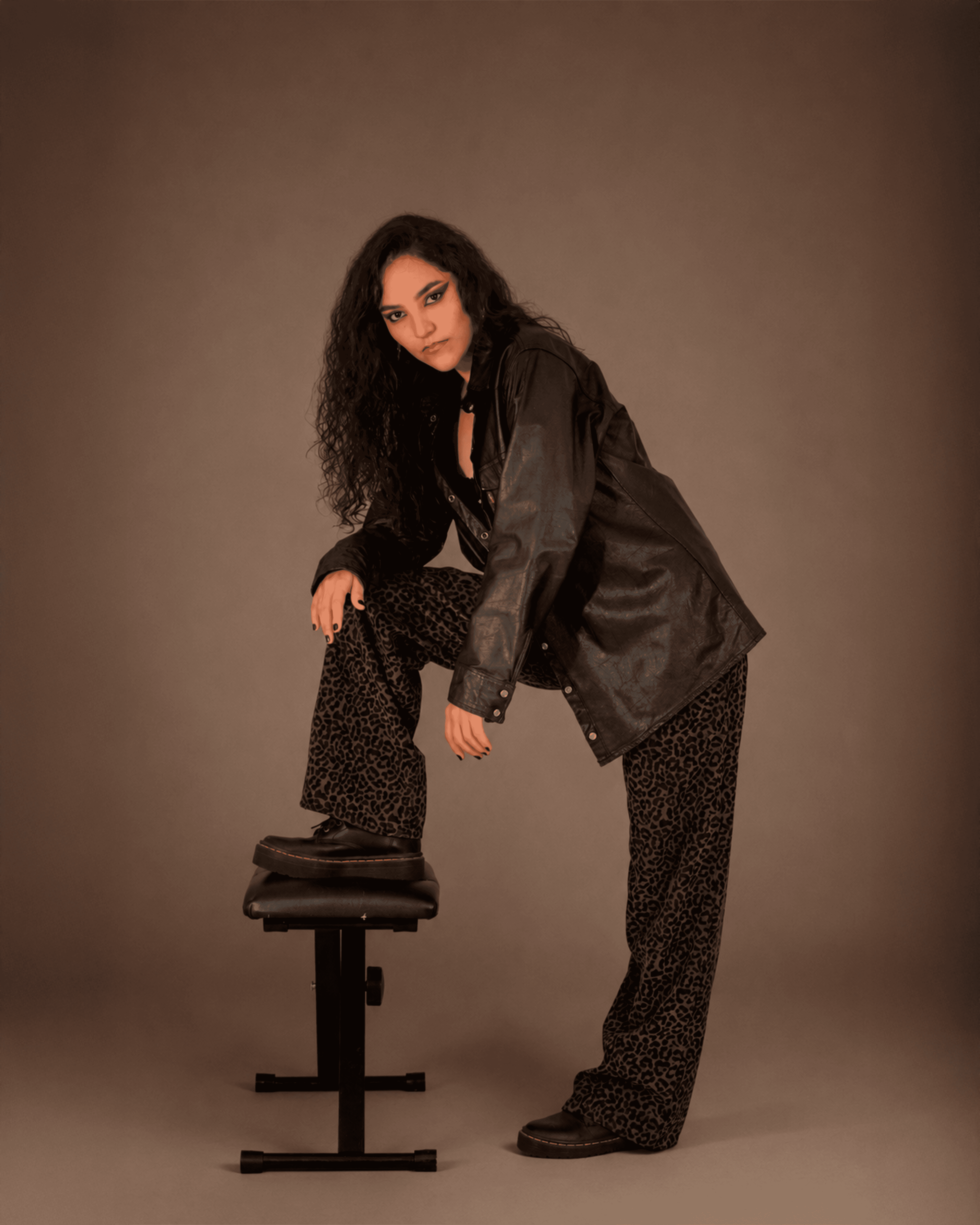 Retrato editorial vertical con postura fuerte y styling oscuro